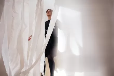 Mężczyzna tańczy. Widać go zza kotary.