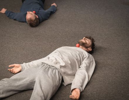 Na podłodze leżą dwaj mężczyźni.