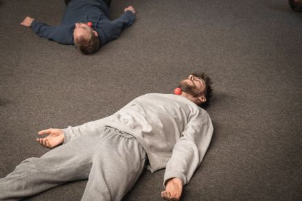 Na podłodze leżą dwaj mężczyźni.
