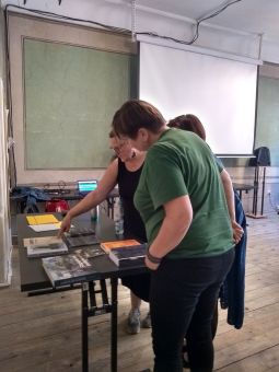 Jedna z kobiet wskazuje palcem na okładkę książki.