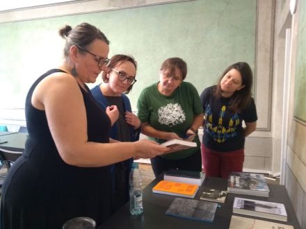 Uczestniczki oglądają książki, które leżą na stoliku.