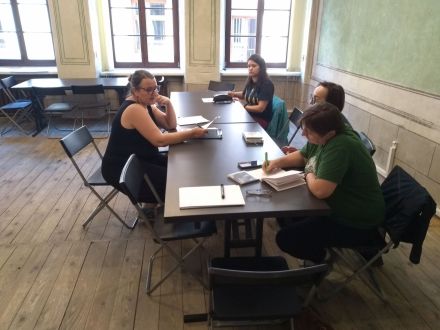 Uczestniczki siedzą przy stole i notują.