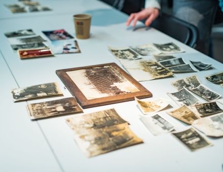 Na stole leżą stare, czarno-białe zdjęcia.