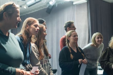 Uczestniczki warsztatów stoją w rzędzie i patrzą przed siebie. Są uśmiechnięte.