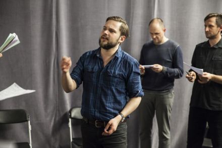 Za zdjęciu prowadzący wszedł do środka koła i pokazuje jednemu z uczestników, jak powinien śpiewać.