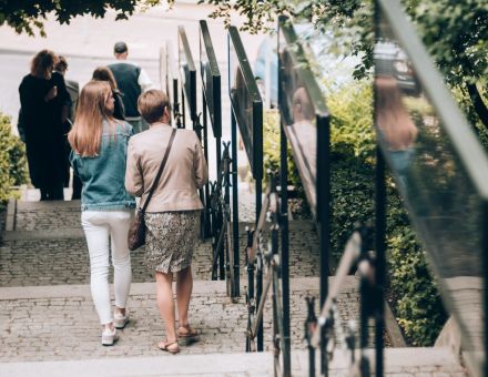 Ludzie schodzą schodami w dół i patrzą na wystawę.