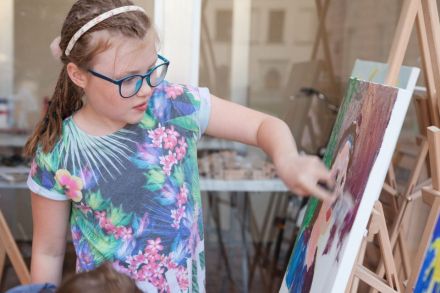 Na zdjęciu widzimy dziewczynkę, która kończy malować swoje dzieło.