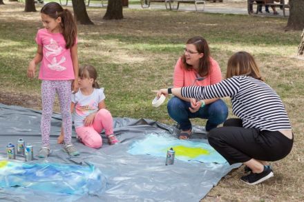 Na zdjęciu  dwie kobiety wraz z dwiema dziewczynkami. Jedna z kobiet pokazuje ręką w jedną stronę i wszystkie kierują tam swój wzrok.