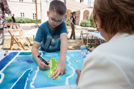 Zbliżenie na chłopca, który markerem obrysowuje rekina na żółto.