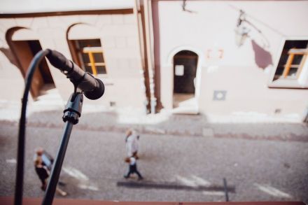 Mikrofon wystawiony na statywie z okna sali MediaLabowej Warsztatów Kultury.  Zdjęcie przedstawia widok z okna na uliczkę Starego Miasta w Lublinie.