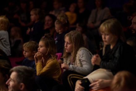 Zgromadzona publiczność, głównie dzieci, wpatrzona w scenę.