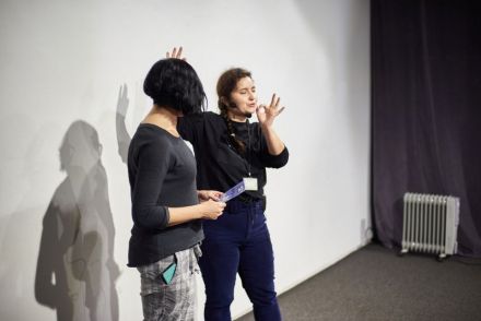 Na zdjęciu nadal duet aktorski, tym razem to koordynatorka, prowadząca spotkanie kieruje swoje słowa w stronę publiczności.