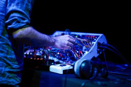 Zbliżenie na mikser do miksowania muzyki oraz dłonie artysty.