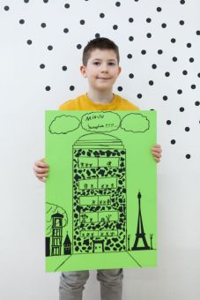 Archiplak Na zdjęciu stoi chłopiec trzymający dumnie plakat przedstawiający wielki budynek otoczony mniejszymi m.in. wieżą Eiffla. Na górze widnieje napis Miasto Szczęścia. Plakat utrzymany w kolorystyce zielono-czarnej.