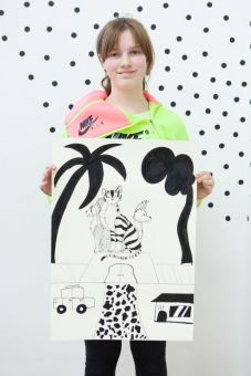 Na zdjęciu stoi dziewczynka trzymająca plakat utrzymany w kolorystyce biało-czarnej.