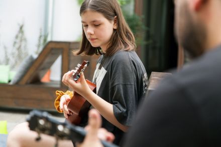 Nastolatka uczy się gry na ululele.