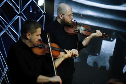 Widok z góry. Na zdjęciu dwóch skrzypków skupionych na grze,