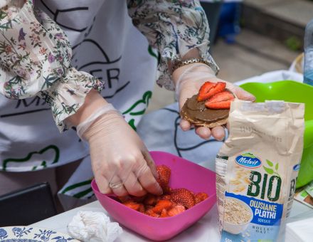 Kobieta kładzie truskawki na ciastko owsiane z czekoladą.