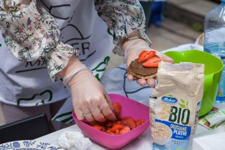 Kobieta kładzie truskawki na ciastko owsiane z czekoladą.