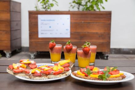 Na stole stoją dwa talerze z przygotowanych przez uczestniczki warsztatów przekąsek oraz kubki z koktajlami.