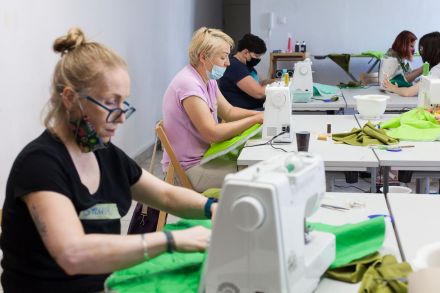 Kobiety zszywają materiały na maszynach.