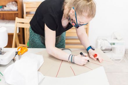 Kobieta rysuje projekt peleryny obciążeniowej.