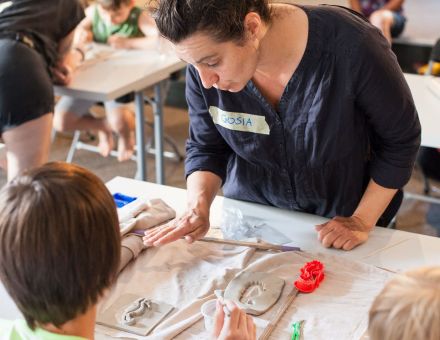 Pani pomaga chłopcu zrobić płaskorzeźbę.