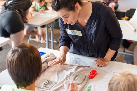 Pani pomaga chłopcu zrobić płaskorzeźbę.