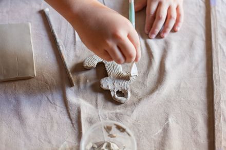 Chłopiec robi szlaczki na swojej płaskorzeźbie.