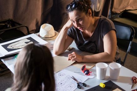 Prowadząca zajęcia pokazuje dziewczynce, jakiego psa z gazet może zrobić.