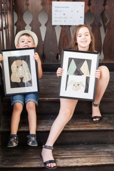 Chłopiec i dziewczynka prezentują swoje gotowe wycinanki.