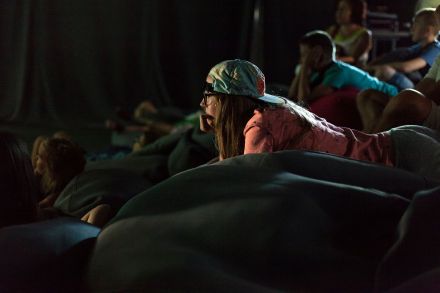 Dzieci z rodzicami oglądają spektakl.