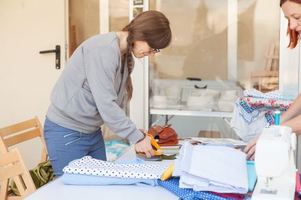 Kobieta wycina materiał nożyczkami.