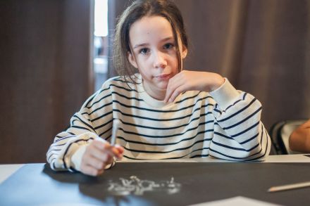 Zbliżenie na dziewczynkę, która rysuje obrazek.