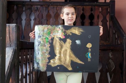 Dziewczynka prezentuje swoją pracę.