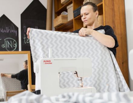 Kobieta pokazuje gotową kołdrę.