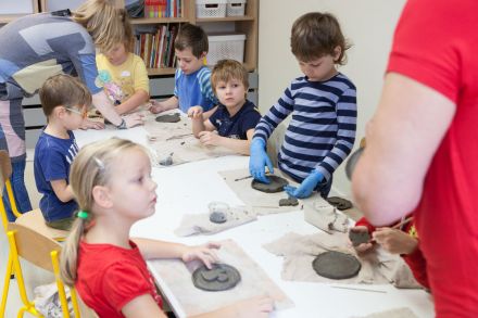 Panie pomagają dzieciom dokończyć ich płaskorzeźby.