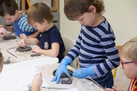 Chłopiec modeluje kształt z gliny.