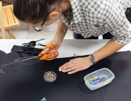 Kobieta wycina nożyczkami krój na kurtkę przeciwdeszczową.