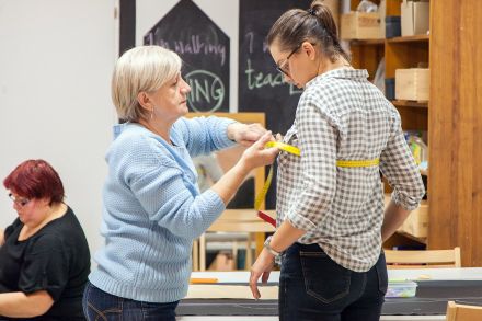 Jedna kobieta mierzy centymetrem drugą.