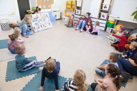 Dzieci siedzą w kole i rozmawiają o swoim plakacie.