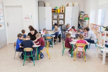 Dzieci siedzą przy czterech stolikach. Każda grupa maluje inny obrazek.