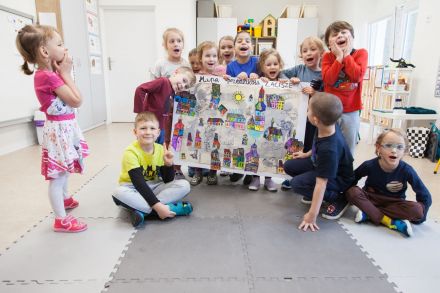 Dzieci siedzą przy czterech stolikach. Każda grupa maluje inny obrazek.