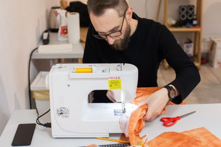 Mężczyzna szyje na maszynie.