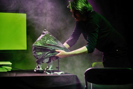 Mężczyzna zakrywa robota czarnym workiem foliowym.