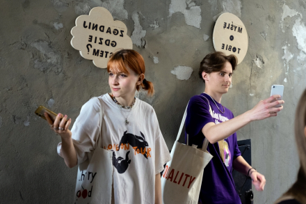 Dziewczyna i chłopak robią sobie selfie z tabliczkami "myślę o Tobie" i "zgadnij gdzie jestem?"