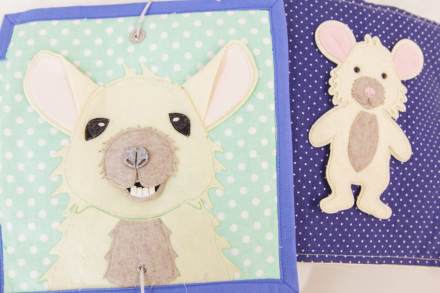 Efekt pracy uczestniczki warsztatów. Książeczka sensoryczna z myszką na okładkce.