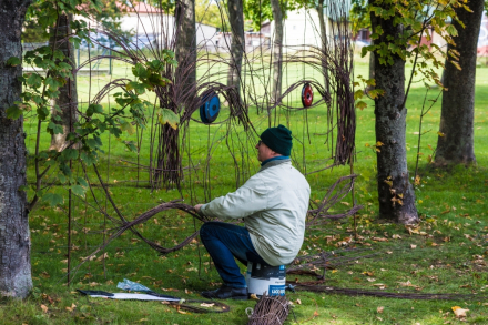 Mężczyzna podczas plecenia ozdoby z wikliny.