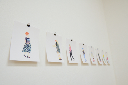 Na białej ścianie widać serię rysunków przedstawiających  różne postacie.