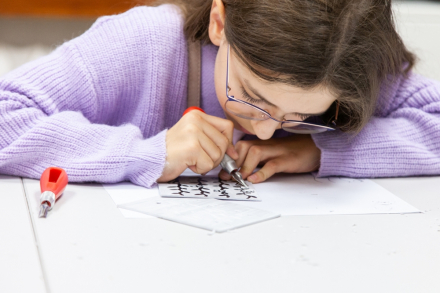 Dziewczynka tworzy linoryt.